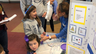 Anne Pino (rightmost) impresses a young participant as her LED light shines blue.
