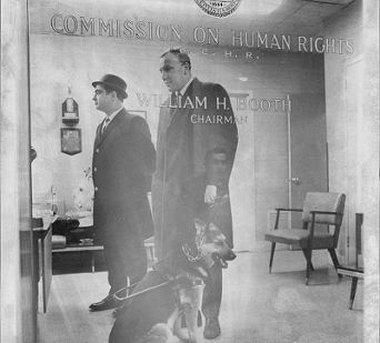 Edwin R. Lewinson and his seeing eye dog in the office of the Commission on Human Rights. 