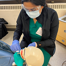 a picture of a dental student performing surgery on a dental model