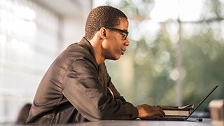 Graduate Student Working on a Laptop