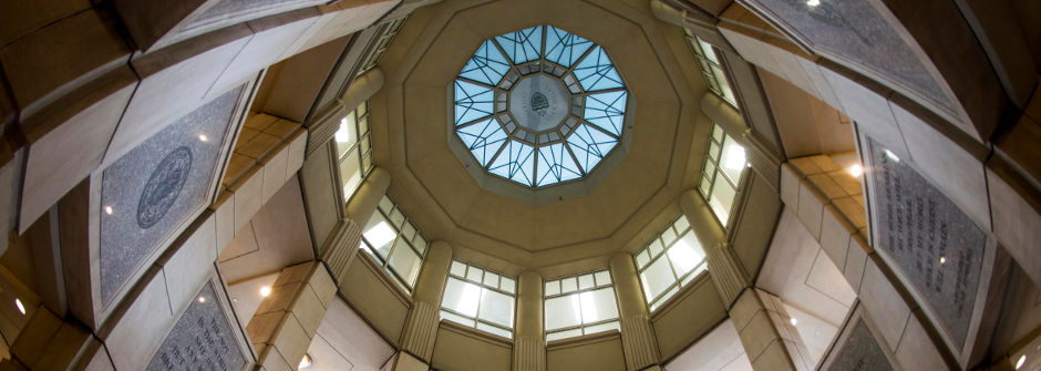 Light shining through the windows of the library rotunda from the ground. 