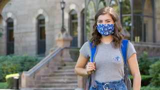 A female student wearing a mask on campus.