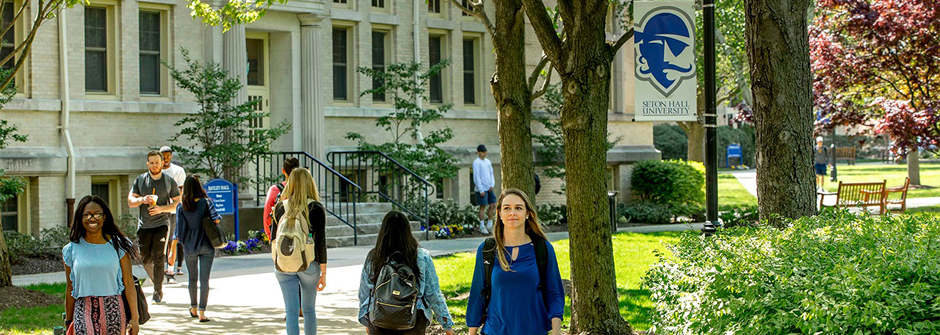 Student walking on campus near Bayley Hall.